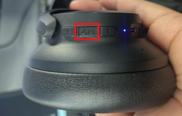 A hand holding a black headphone AI-generated content may be incorrect.